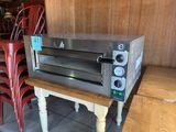 a toaster oven sitting on a table in the middle of a room