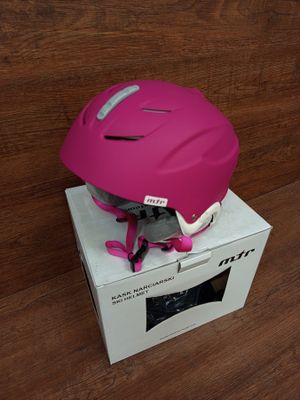 a pink helmet sitting on top of a box on a wooden floor