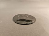 a silver coin with a face on it sitting on a table