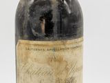 Des bouteilles de vin sont posées sur une surface blanche, devant un fond blanc.