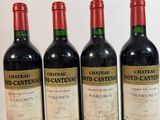 quatre bouteilles de vin sont alignées sur une surface blanche