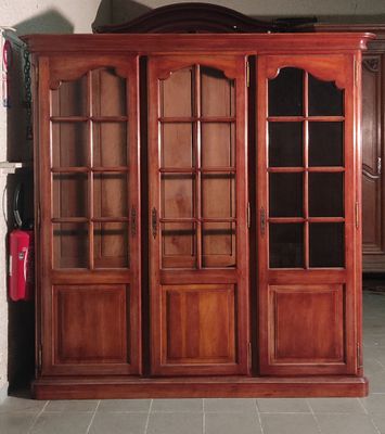 un grand meuble en bois avec des portes en verre dans une pièce