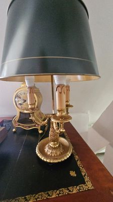 une table sur laquelle se trouvent une lampe et une horloge