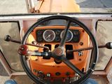 a steering wheel and dashboard of an orange tractor
