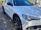 a white alfa suv parked in front of a building