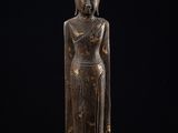 une statue en bronze représentant une personne sur fond noir