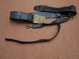 un gros plan d'une ceinture en cuir noir avec une boucle en laiton