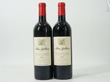 deux bouteilles de vin rouge posées l'une à côté de l'autre sur une surface blanche
