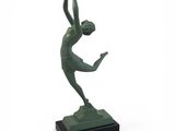 statue d'une femme tenant une raquette de tennis, posée sur un socle en marbre