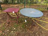 une table et une chaise qui se trouvent dehors, dans l'herbe