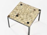 a small table with a tiled top on a white surface