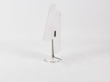 lampe en forme de triangle posée sur un socle transparent muni d'un support métallique