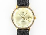an image of a gold watch with a black strap