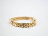 a close up of a gold bracelet on a white surface