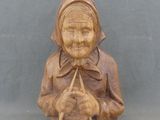 statue en bois sculpté représentant une femme tenant un chat, sur fond bleu