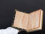 someone is holding a book with a marbled design on it