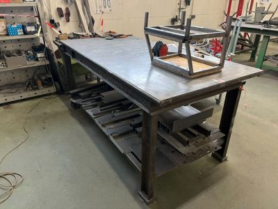un établi au milieu d'un atelier, sur lequel sont posés des outils