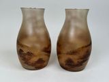 two brown vases sitting on top of a table next to each other