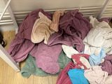 a pile of clothes on the floor next to a table