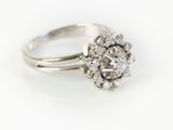 a close up of a diamond ring on a white surface