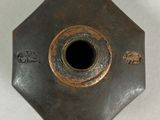 a metal object with a hole in it on a white surface