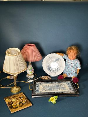 une poupée assise à côté d'une table sur laquelle se trouve une assiette