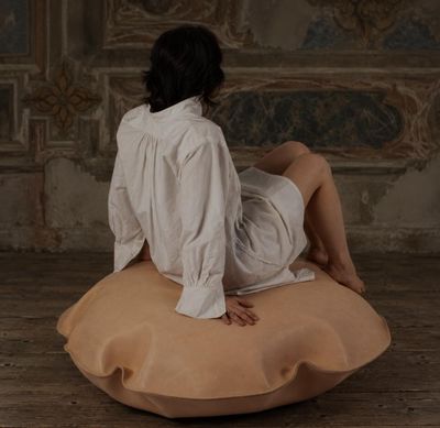 une femme assise sur un coussin dans une pièce