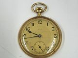 une montre de poche en or sur une surface blanche
