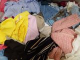 a pile of clothes that is sitting on a bed