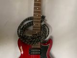 une guitare rouge accrochée au mur avec une corde