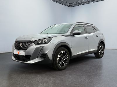 un SUV argenté garé dans une pièce blanche au sol noir