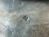 a silver vase with a crown on it sitting on a table