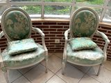 une paire de chaises vertes et blanches placées devant une fenêtre