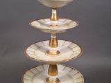 a close up of a three tiered cake plate on a table