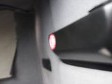 a close up view of a car door handle with a red light on it