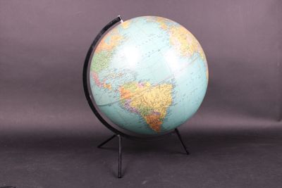 an image of a blue and green globe on a black stand