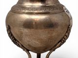 a silver vase on a stand on a white background