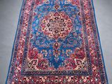 a blue and red rug with a medallion design