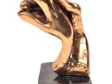 statue représentant une main dont un doigt est levé, posée sur un socle noir