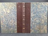 un vieux livre à la couverture bleue et marron posé sur une table