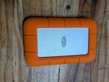 un disque dur orange et blanc posé sur une table en bois