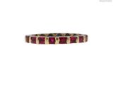 a close up of a ring with a red stone in it