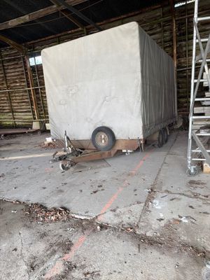 un camion garé dans un bâtiment et recouvert d'une bâche
