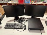 two computer monitors and a keyboard on a desk