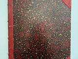 un vieux livre à la couverture rouge posé sur une table