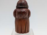 an old wooden figurine of a man with a hat on his head