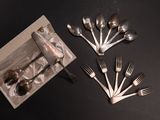 a box with a bunch of silver spoons and forks