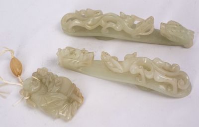 trois pièces de jade sculpté sont posées sur une surface blanche