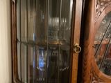 a wooden cabinet with a glass door on top of it