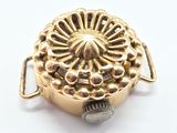 a close up of a gold plated object on a white surface